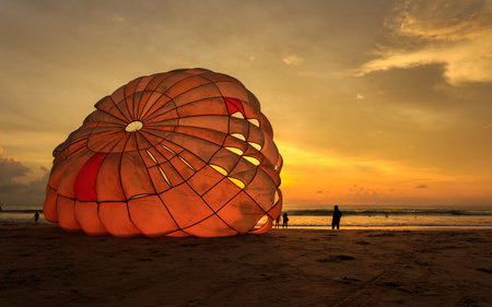 Silhouette of man is preparing para sailing at the sunset beach in Thailandの写真素材