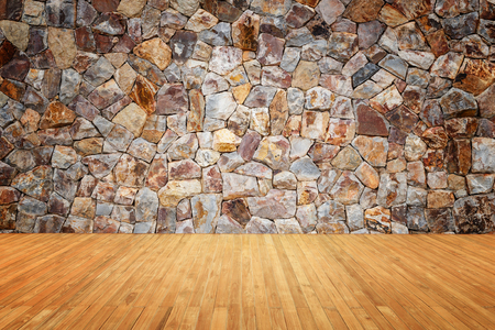 Empty top of wooden floor and natural stone wall backgroundの写真素材