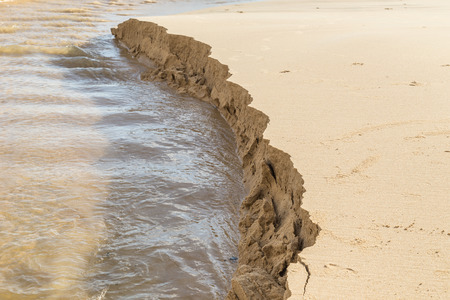 Sand structure while scouring by water at the beachの写真素材