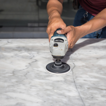 Man polishing marble stone table by small angle grinderの写真素材