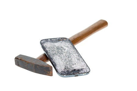 Close up hammer and broken smart phone isolated on white backgroundの写真素材