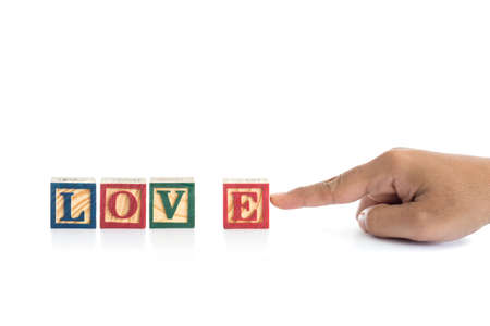 LOVE write in colorful wood alphabet blocks and hand holding E isolated on white background