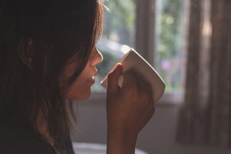 Close up woman holding coffee cup in morning time, focus on handの写真素材