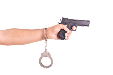 Close up man with handcuffs and gun on hands isolated on white backgroundの写真素材
