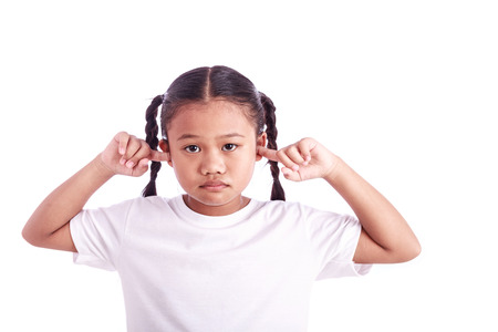 Portrait of young Asian girl with finger closing ear isolated on white backgroundの写真素材