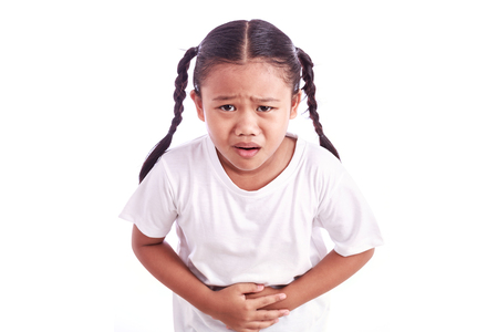 Portrait of young Asian girl isolated on white background : Stomachache conceptの写真素材