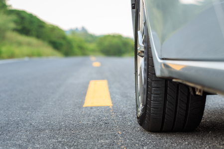 Close up front car wheel on the asphalt roadの写真素材