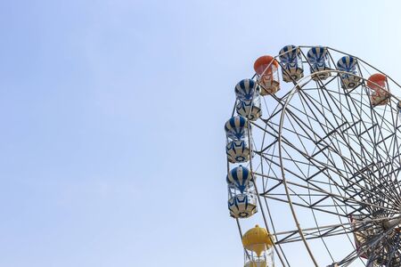 Brightly colored Ferris wheel against the blue sky