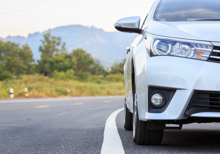 Close up front of new silver car parking on the asphalt roadの写真素材