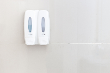 White shampoo and soap bottle on bathroom wallの写真素材
