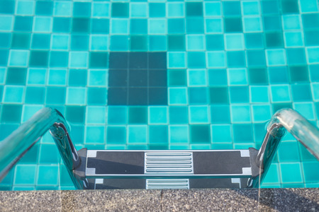 Outdoor swimming pool with shiny stainless steel stair