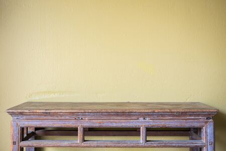 Empty top vintage wooden table and yellow cement wall background. For product displayの写真素材