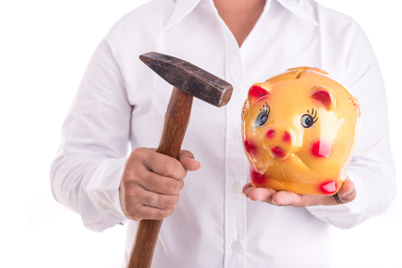 Woman holding hammer and yellow piggy bank isolated on white background. Breaking conceptの写真素材