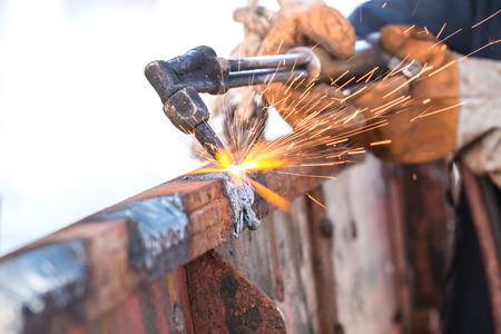 A worker cutting steel using metal torch