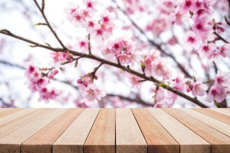 Empty top wooden table and flower field blurred background. Can use for product displayの写真素材