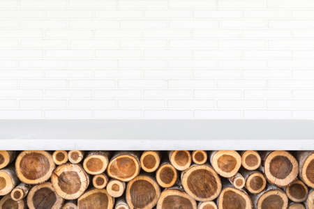 Empty top of stone table or counter with pile of wood log on stone wall background. For product displayの写真素材