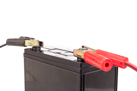 Close up hand holding car battery jump start isolated on white backgroundの写真素材