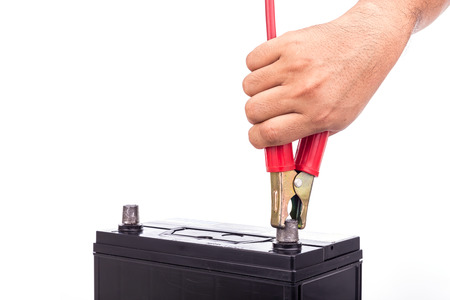 Close up hand holding car battery jump start isolated on white background