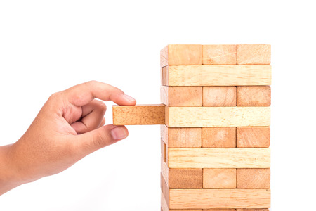 Close up hand holding blocks wood game  isolated on white background. Risk concept