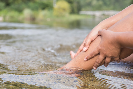 Close up woman legs while sitting in the river. Healthy conceptの写真素材