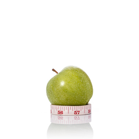 Green apple with measurement tape. Healthy concept. Studio shot isolated on white backgroundの写真素材