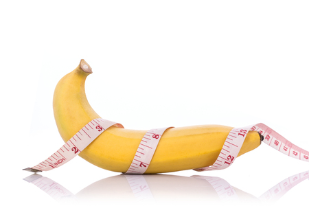 Close up yellow banana with measurement tape. Men penis size concept.
Studio shot isolated on white backgroundの写真素材