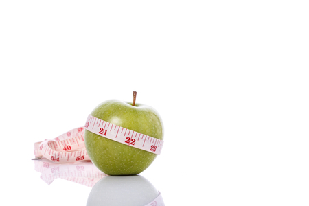 Green apple with measurement tape. Healthy concept. Studio shot isolated on white backgroundの写真素材