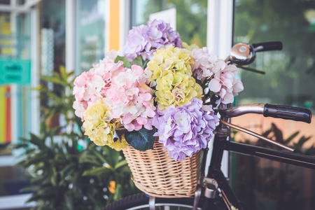 Bouquet of flower in bucket on front of vintage bicycle. Garden decoration. Vintage colorの写真素材