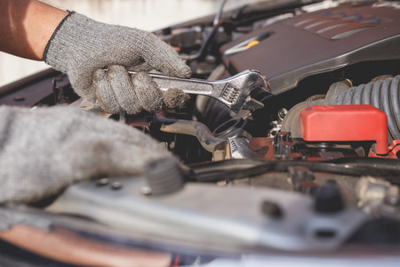 Hand of technician checking or fixing engine of modern carの写真素材