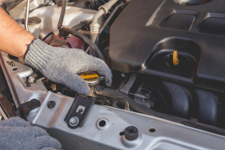 Hand of technician checking or fixing engine of modern carの写真素材