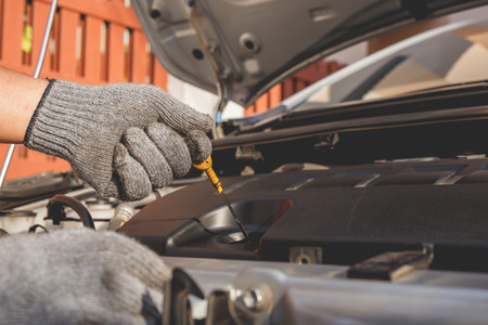 Hand of technician checking or fixing engine of modern carの写真素材