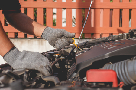 Hand of technician checking or fixing engine of modern carの写真素材
