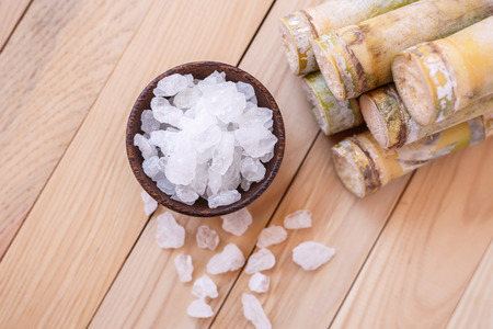 Close up rock sugar and sugar cane on wooden table backgroundの写真素材