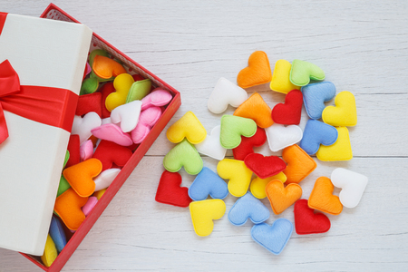 Top view colorful heart shape in gift box with ribbon on white wooden plank background. For love or valentine day conceptの写真素材