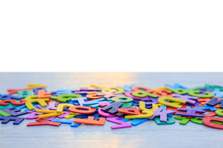 Colorful wooden alphabet. Top view on white wooden background