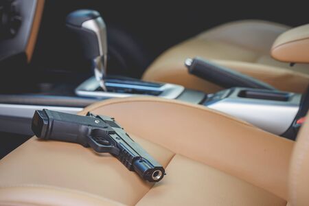 Close up black gun inside the car. For violence on the road conceptの写真素材