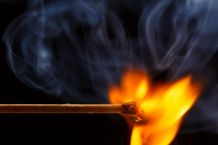 Macro fire burning on matchstick. Studio shot isolated on black background