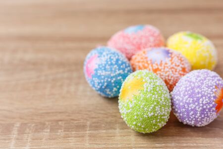 Top view artificial color eggs on wooden plank background. For Easter day use