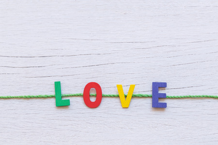 Colorful wooden alphabet and LOVE word on white wooden backgroundの写真素材