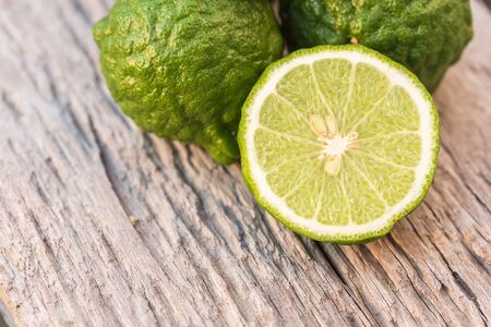 Close up slice green fresh Bergamot fruit on wooden table backgroundの写真素材