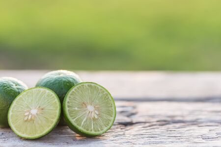 Close up slice green fresh lemon on wooden table backgroundの写真素材