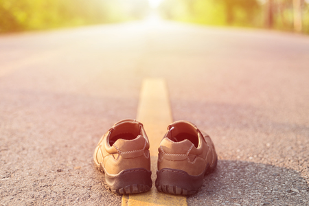 Close up new men fashion shoes on asphalt road beside yellow stripeの写真素材