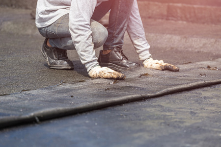 Asia worker installing tar foil on the rooftop of building. Waterproof system by gas and fire torchingの写真素材