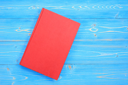 Top view old red book on wooden plank background. Blank empty cover for designの写真素材
