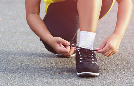 Close up woman tying sports her shoe. Prepare for run in the parkの写真素材