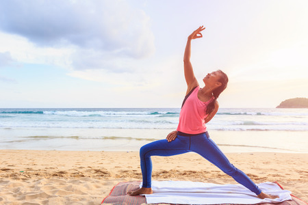 Asian woman playing Yoga and exercise on the tropical beach in Thailandの写真素材
