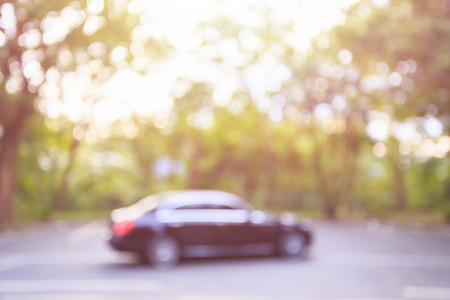 Blurred background : Empty car parking space in public the park surrounding by the treeの写真素材