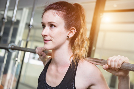 Beautiful young caucasian woman doing exercise with exercise equipment and machine in gym. Health...