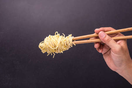 Close up traditional Thai yellow noodle on black stone table backgroundの写真素材
