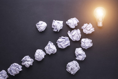 Top view crumpled white paper and light bulbs on black stone board. Create idea conceptの写真素材